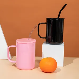 Detail shot of modern pink and black borosilicate glass mugs with lids and glass straws.