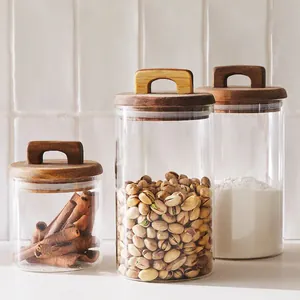 Set of three glass storage jars with wooden handle lids for kitchen pantry organization