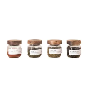 Juego de cuatro botes de especias de vidrio con tapas de madera de acacia y etiquetas