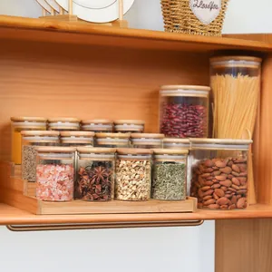 Set completo di 12 barattoli per spezie in vetro con coperchi in bambù su scaffale in legno