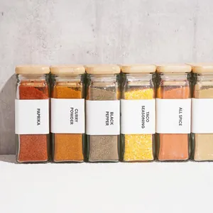 Detailed view of square glass spice jars with eco-friendly bamboo lids and white labels