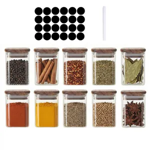 Gruppenansicht quadratischer Gewürzgläser aus Glas mit Akazienholzdeckeln und Etiketten.