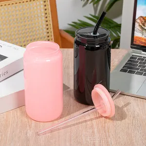 Stylish pink and black 16oz borosilicate glass can cups with lids and straws on a wooden desk