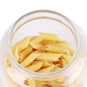 Top view detail of a clear borosilicate glass storage jar filled with penne pasta