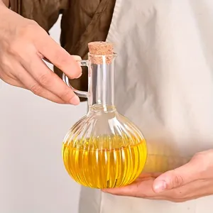 Vue détaillée d'une bouteille d'huile en verre borosilicaté nervuré avec bouchon en liège