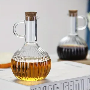 Vue détaillée d'un distributeur d'huile en verre nervuré avec un bouchon en liège naturel.