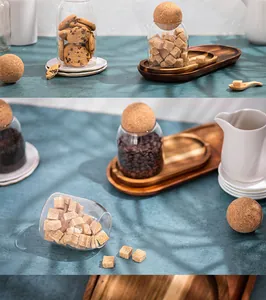 Close-up of clear glass storage jars with spherical cork lids in a kitchen setting
