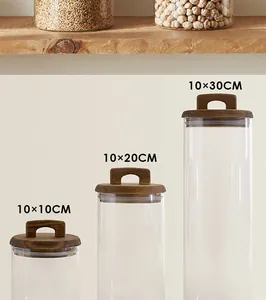 Three glass kitchen storage canisters with acacia wood handle lids in three different sizes