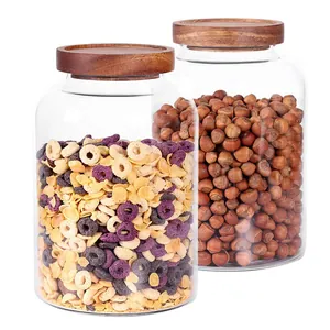 Detail view of large borosilicate glass jars with acacia wood lids for food storage.