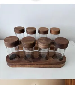Detailed view of 8-piece glass spice jar set with acacia wood lids and wooden base