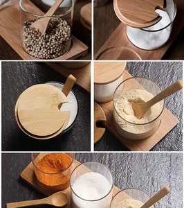 Detailed view of clear glass seasoning jars with bamboo lids and wooden spoons.