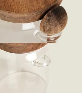 Makroansicht des hochwertigen Glasvorratsbehälters mit Holzdeckel und Löffelhalter.