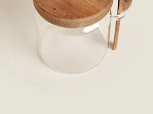 Detailansicht eines Glas-Vorratsglases mit Holzdeckel und dazugehörigem Holzlöffel
