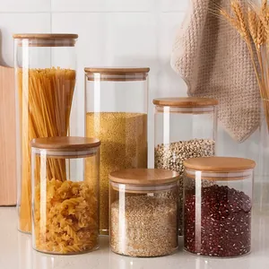 Set of glass food storage jars with airtight bamboo lids in a warm kitchen setting