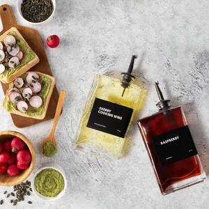 Detail view of two glass condiment dispensers with black labels on a kitchen counter