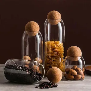 Elegant glass storage jars with round cork ball lids for coffee beans and dry pasta