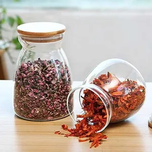 Macro view of transparent trapezoidal glass jars with bamboo lids for storing flower tea.