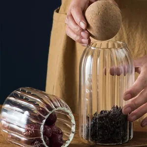 Macro detail of clear ribbed glass storage jar featuring a natural cork ball lid.