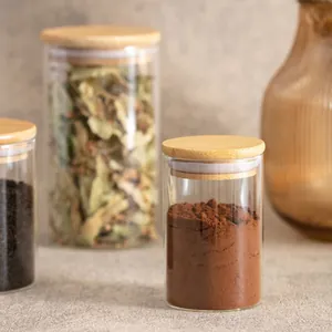 Dettaglio di barattoli in vetro con coperchi in bambù per conservare cacao e tè