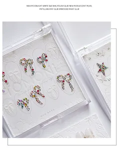 Detailed macro of 3D embossed nail stickers featuring rhinestone bows and stars