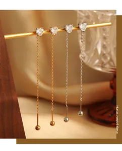 Detailed view of heart-shaped cubic zirconia chain earrings in gold and silver finish
