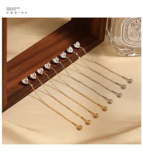 Detailed view of heart-shaped cubic zirconia long chain thread earrings in gold and silver