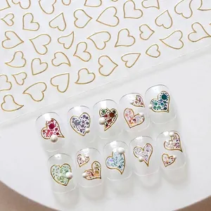 Elegant gold heart-shaped hollow nail art stickers displayed on clear press-on nails.