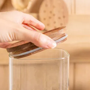 Detailansicht eines quadratischen Glasvorratsglases mit einem Deckel aus Akazienholz
