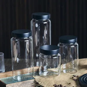 Collection of four various sized airtight glass storage jars with matte black lids
