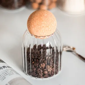 Close-up of a ribbed glass jar with a round cork ball lid containing coffee beans.