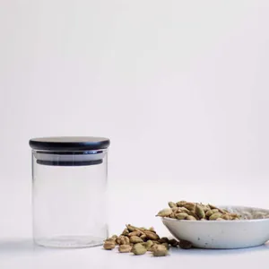 Detailansicht eines 200ml Gewürzglases mit schwarzem Holzdeckel und Kardamomsamen.