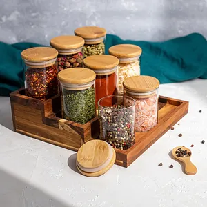 Dettaglio di barattoli per spezie in vetro borosilicato con coperchi in bambù e rack legno.