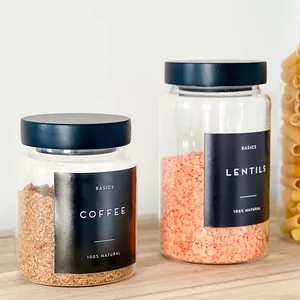 Detail view of two glass storage jars with black pine lids filled with coffee and lentils