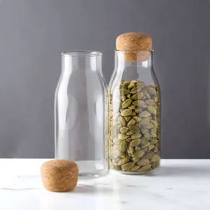 Paire de bocaux de stockage en verre transparent avec couvercles en liège sur marbre blanc