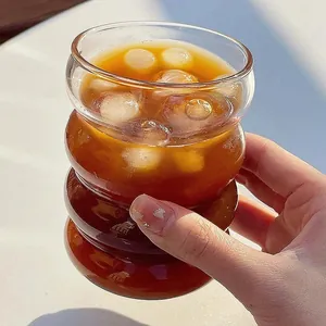 Macro view of unique caterpillar glass cup filled with chilled coffee and fresh ice cubes