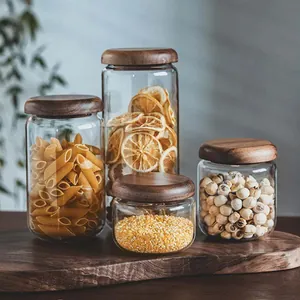 Set of clear glass storage jars with acacia wood lids in various sizes for kitchen use
