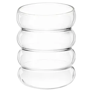Macro detail of a transparent caterpillar-shaped glass water cup with unique ribbed texture