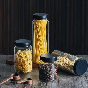 Detailed view of glass storage jars with airtight black pine wood lids in a kitchen setting