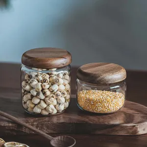 Close-up detail of transparent glass storage jars with rustic acacia wood lids