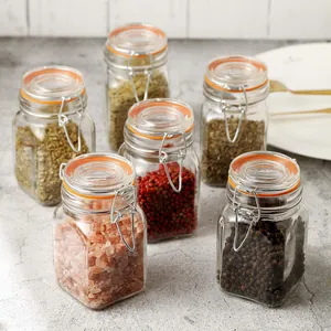 Set of six airtight square glass spice jars with orange seals and metal wire bails.