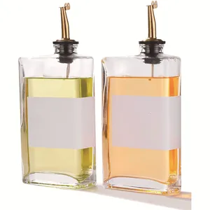 Detailed close-up of two 350ml glass oil dispensers with gold-colored non-drip pourers.