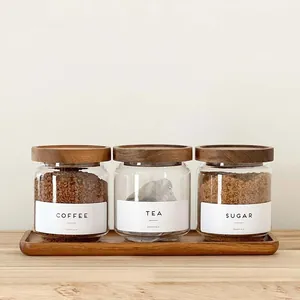 Set of three glass storage jars with acacia wood lids and tray for kitchen organization