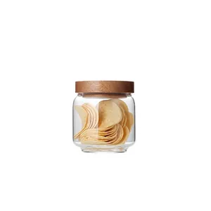 Clear glass storage jar with acacia wood lid for food organization and home decor.