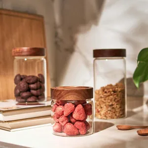 Detalle de un tarro de cristal con tapa de madera de acacia y fresas deshidratadas.