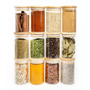 Ensemble de 12 bocaux à épices en verre avec couvercles en bambou et divers assaisonnements.
