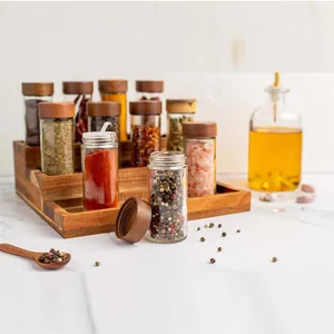 Macro view of clear glass spice jars with acacia wood lids on a wooden shelf