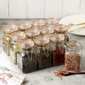 Set of small airtight glass spice jars filled with various colorful seasonings and salts