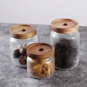 Drei Vorratsgläser aus Hammerschlagglas mit Holzdeckel für die Küchenorganisation