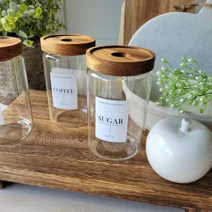 Détail de bocaux en verre avec couvercles en bois d'acacia sur une planche en bois.