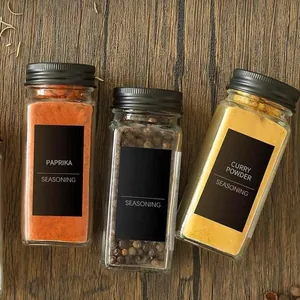 Detailweergave van vierkante glazen kruidenpotjes met zwarte aluminium deksels